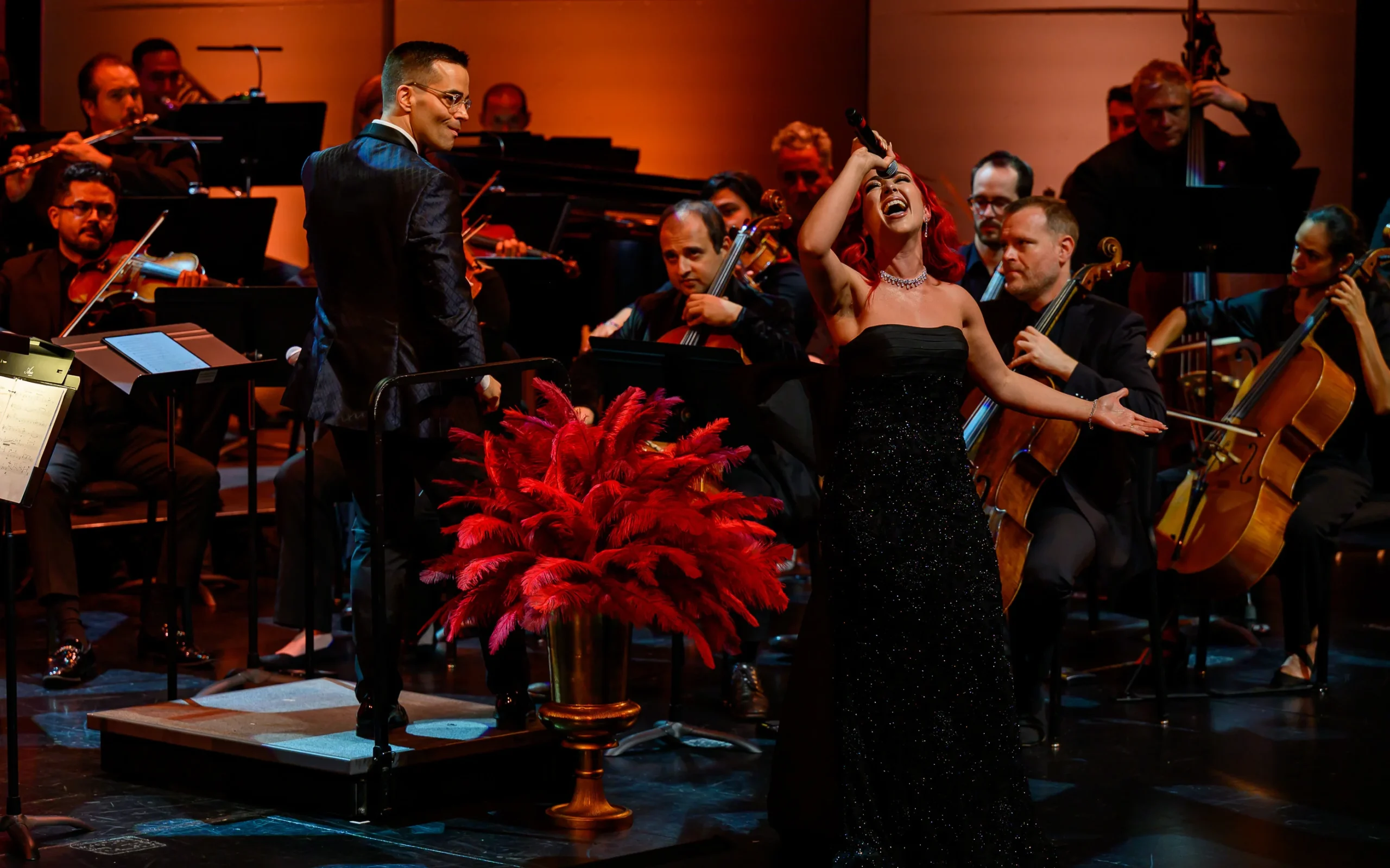 Monique Abbadie singing with the orchestra visible all around her.