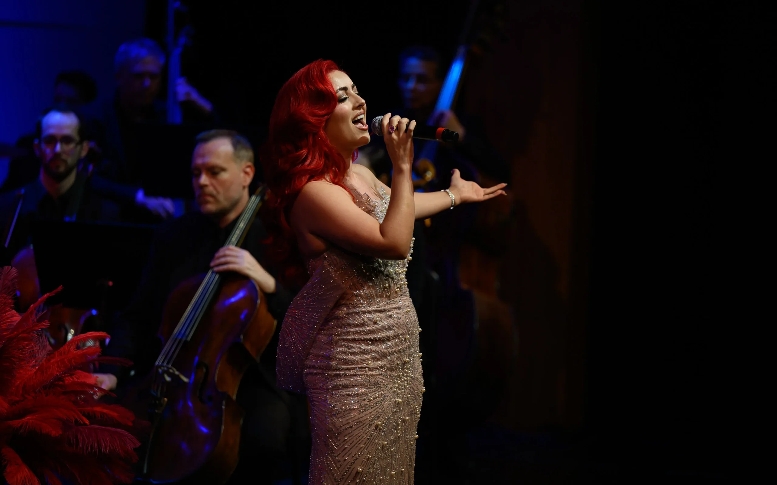 Monique Abbadie performing as the orchestra plays around her.