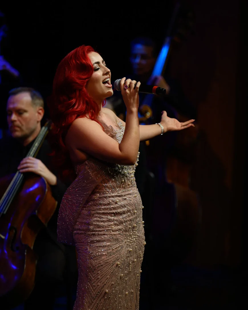 Monique Abbadie performing as the orchestra plays around her.