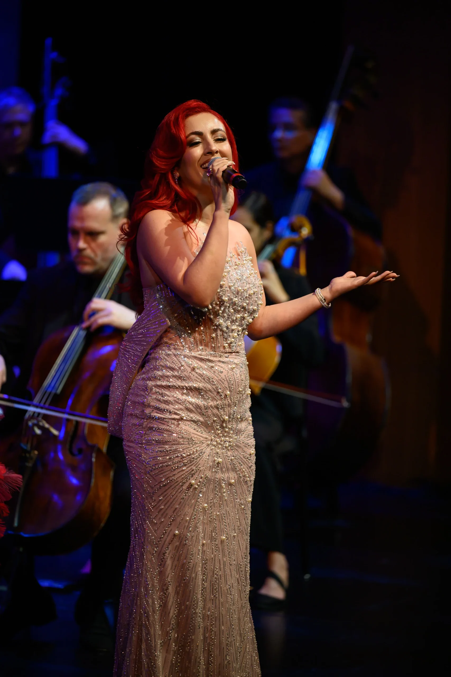 IMG_7066 Monique Abbadie singing, one hand extended toward the audience.