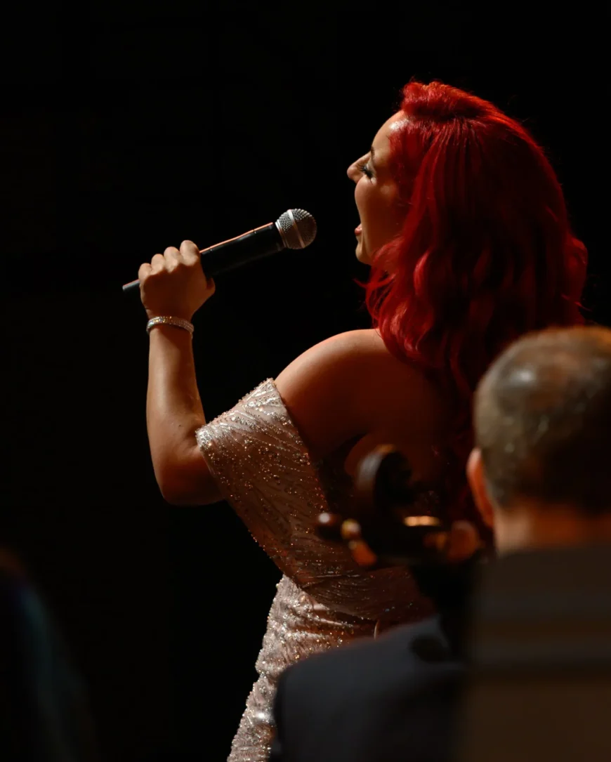 Monique Abbadie performing with expressive intensity at the mic.